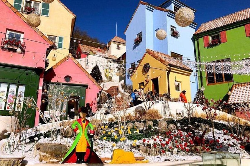 A colorful village with houses, a person in a colorful dress, and a snowy landscape. 3