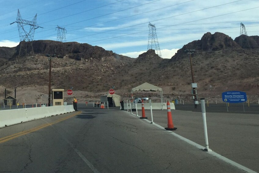 A checkpoint with stop signs, security tents, and a sign for a security checkpoint. 5