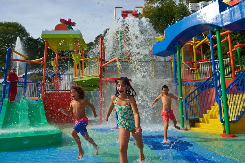 Children playing in a water park with colorful slides and water features. 3
