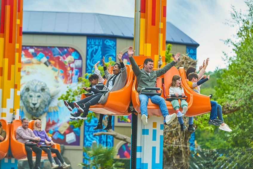 People on a roller coaster with orange seats. 2
