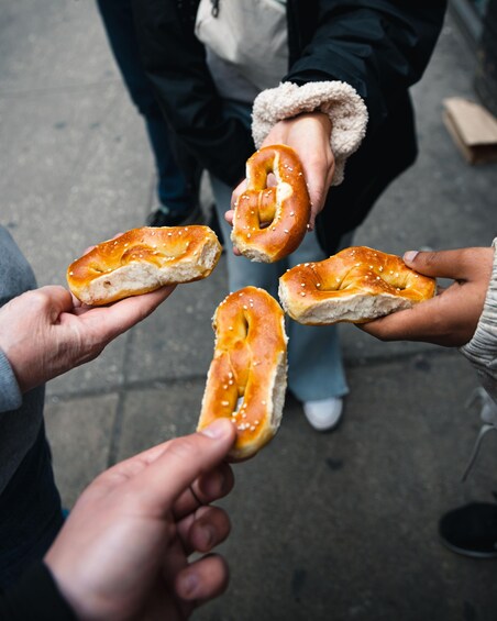 Four people holding pretzels. 4