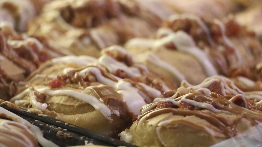 A tray of pastries with white icing and caramel drizzle. 5