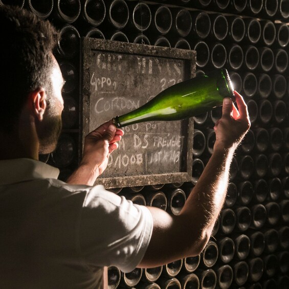 A person pouring a green bottle into a chalkboard with text. 3