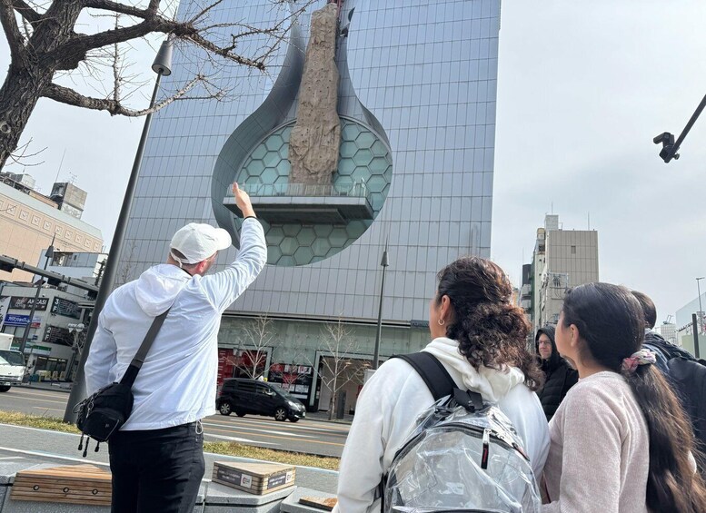 A group of people observing a modern building with a unique hexagonal window design. 5