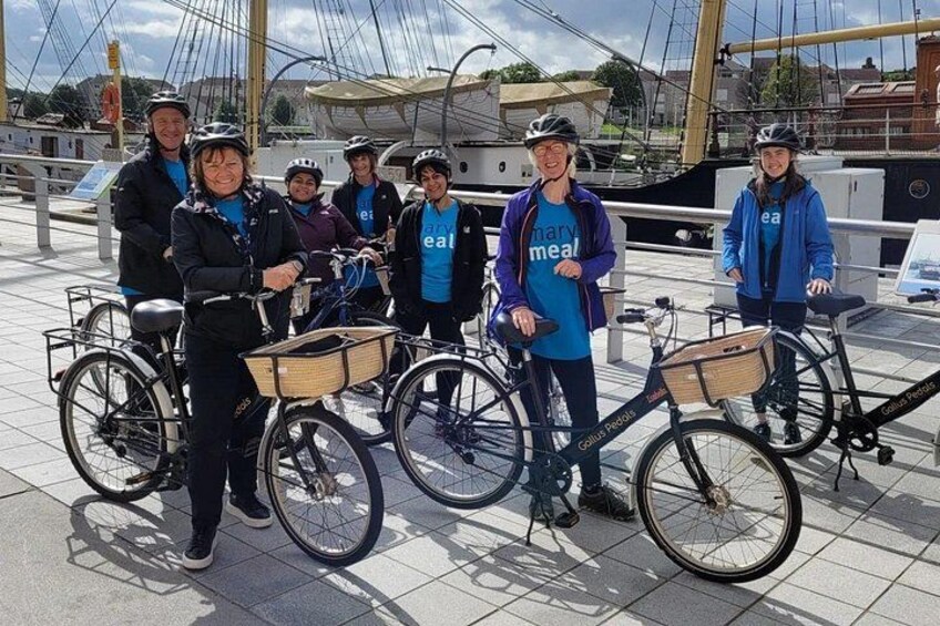 Bike tour guests from Mary's Meals, by the River Clyde outside the Riverside Museum (which takes all artefacts from the Transport Museum), by the Tall Ship 5