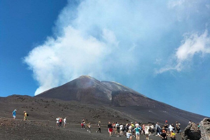A volcanic mountain with a crowd of people at its base. 5