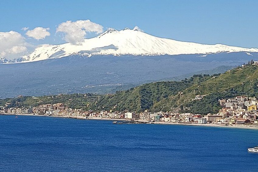 A coastal city with a snow-capped mountain in the background. 4