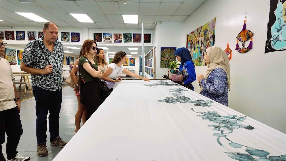 A group of people at an art exhibition with paintings on the walls. 4