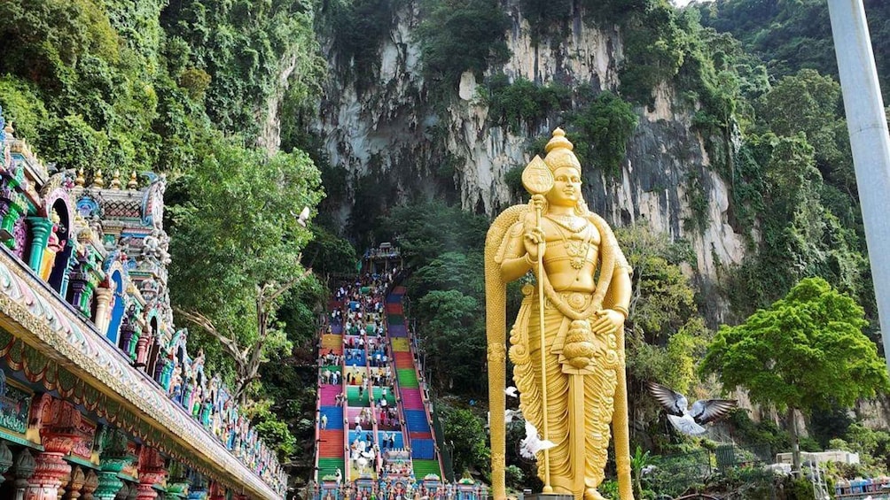 A large golden statue, a colorful staircase, and a temple with intricate architecture. 1