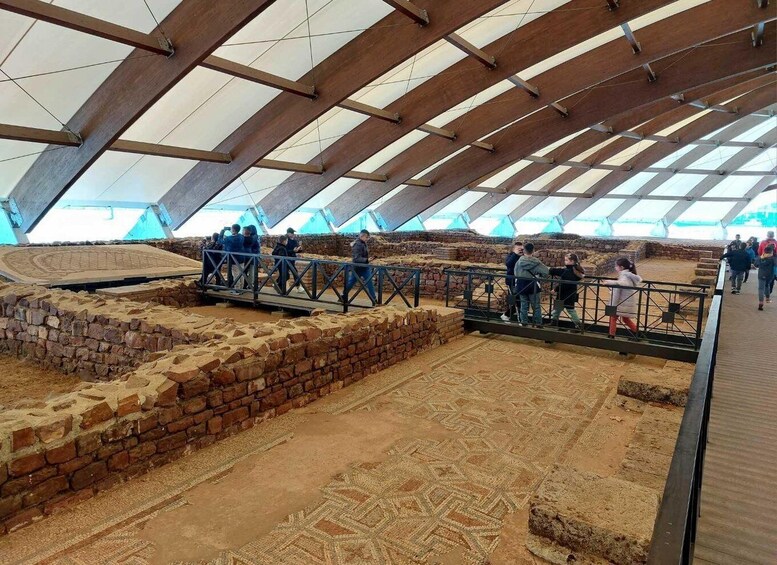 An archaeological site with exposed brick walls and patterned ground. 5