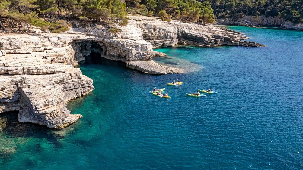 A coastal landscape with rocky cliffs and clear turquoise waters. 1
