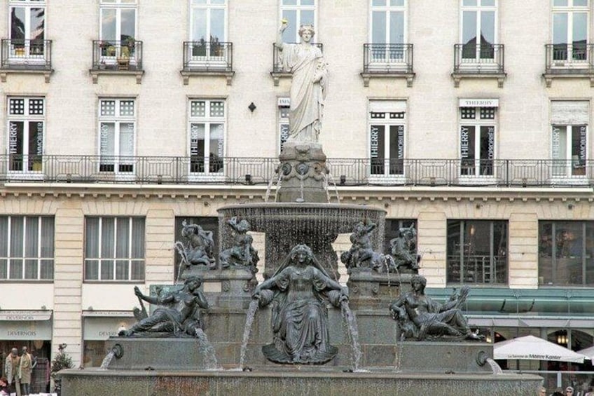 Una fontana neoclassica con statue e un edificio sullo sfondo. 2