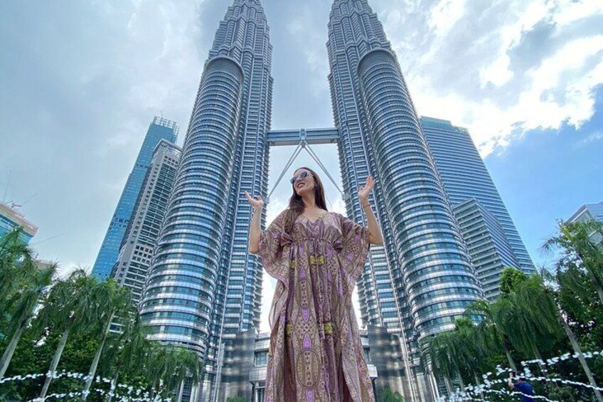 Une personne portant une robe à motifs, debout devant les tours Petronas. 5