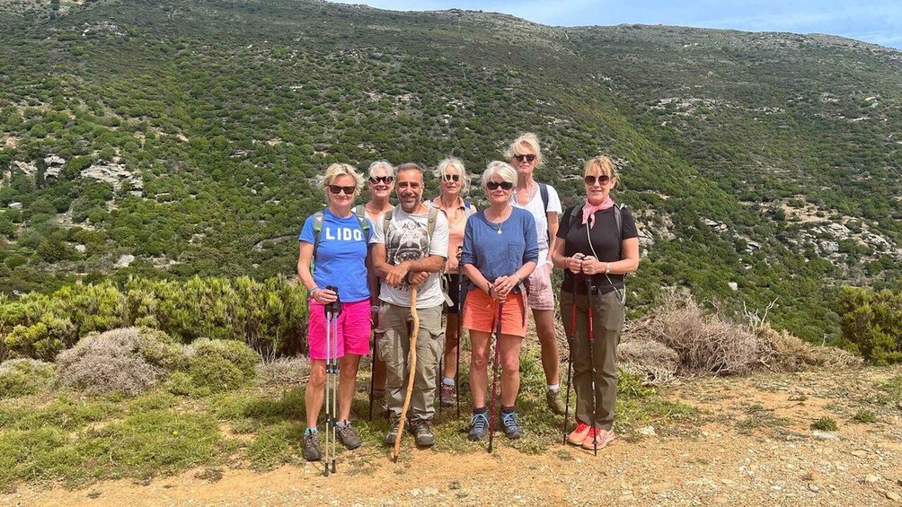 A group of people standing on a hill with a mountainous landscape in the background. 2