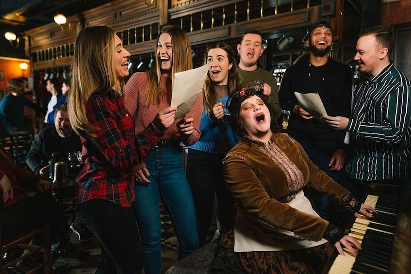 A group of people in a bar, some holding papers and one playing a piano. 3