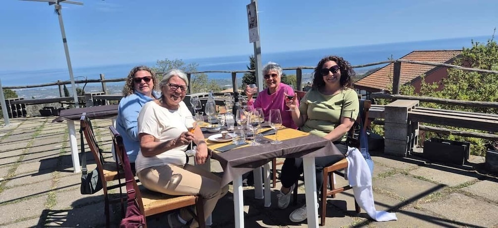 Eine Gruppe von Menschen sitzt an einem Tisch mit Blick auf das Meer. 2