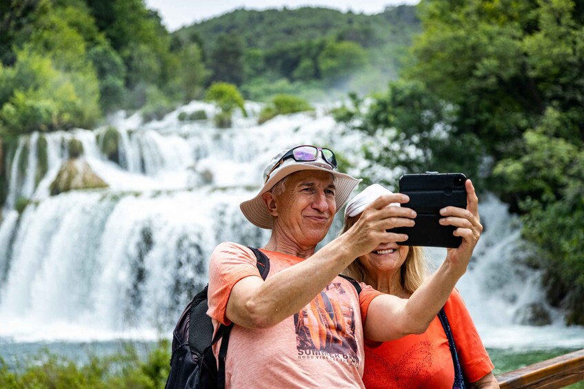 Ein Paar macht ein Foto von einem Wasserfall. 1