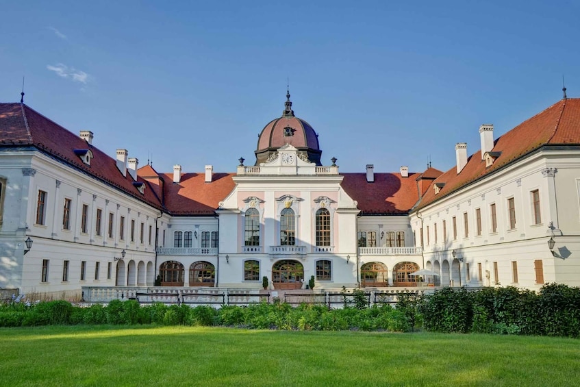 A large, historic building with a central dome and symmetrical wings. 1