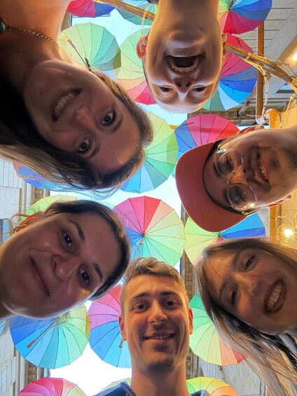 A group of people looking up at colorful umbrellas. 2