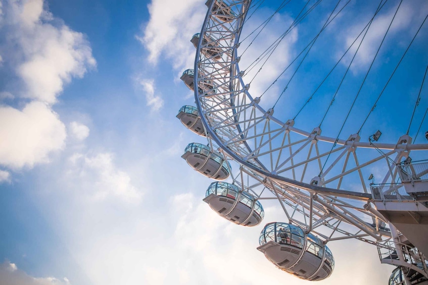 A Ferris wheel against a blue sky with clouds. 5