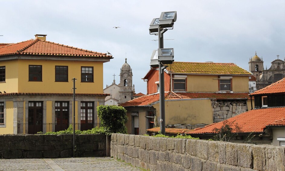 A cobblestone street with historic buildings, a church tower, and a street lamp. 4