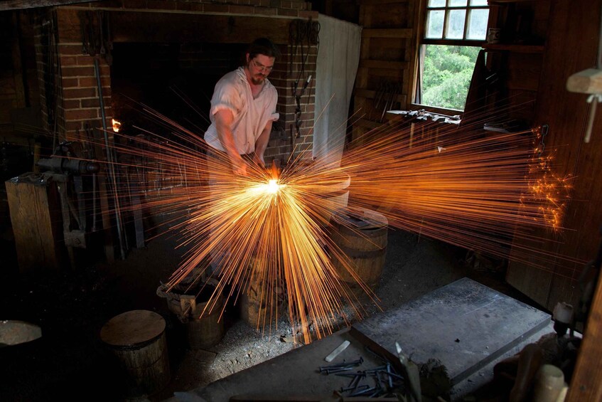 A person working with sparks in a workshop with brick walls and wooden tools. 3