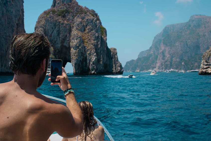 Una persona fotografa una costa rocciosa con scogliere e l'oceano. 2
