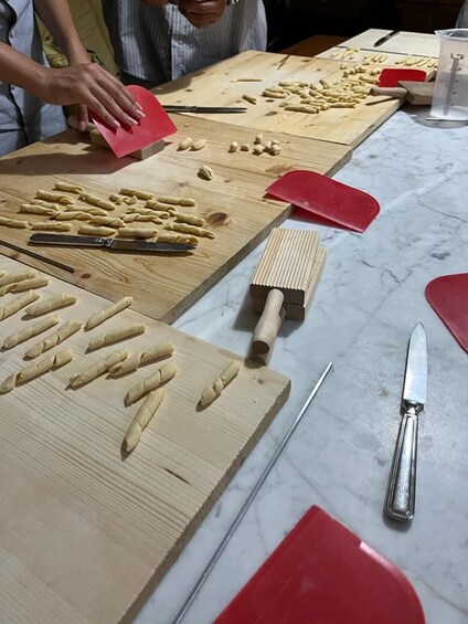 Una persona stende la pasta su un tagliere di legno. 5