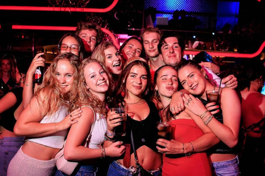 A group of people at a social event, some holding drinks. 1