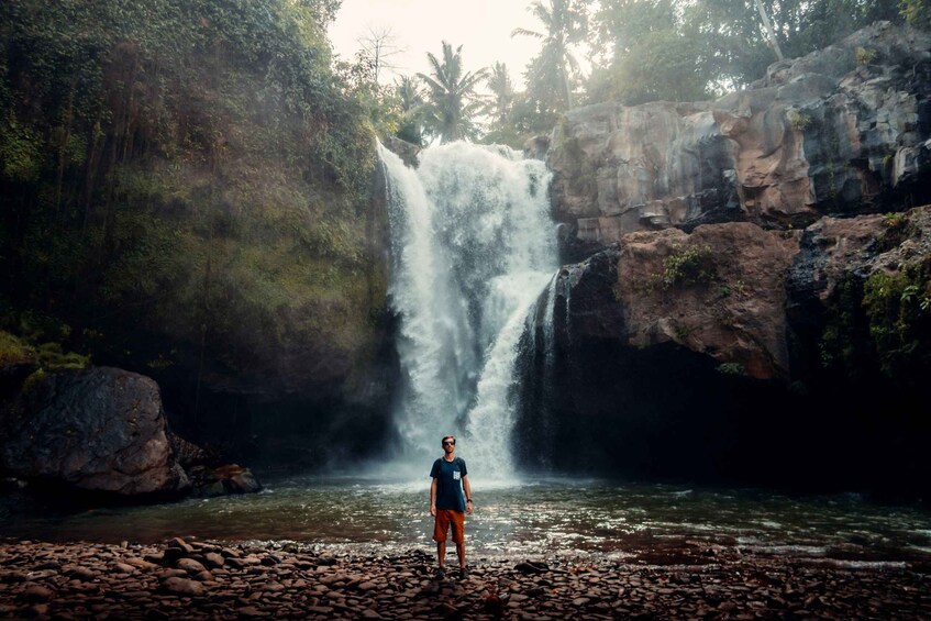 Una cascata in una zona boschiva, con una persona in primo piano. 3