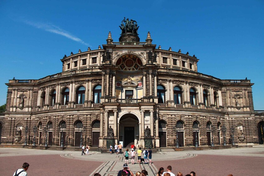 A historic building with a large central archway and statues on either side. 3