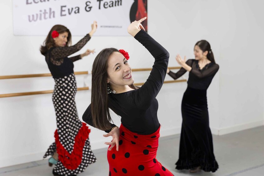 Three dancers in a dance studio with ballet barres in the background. 1