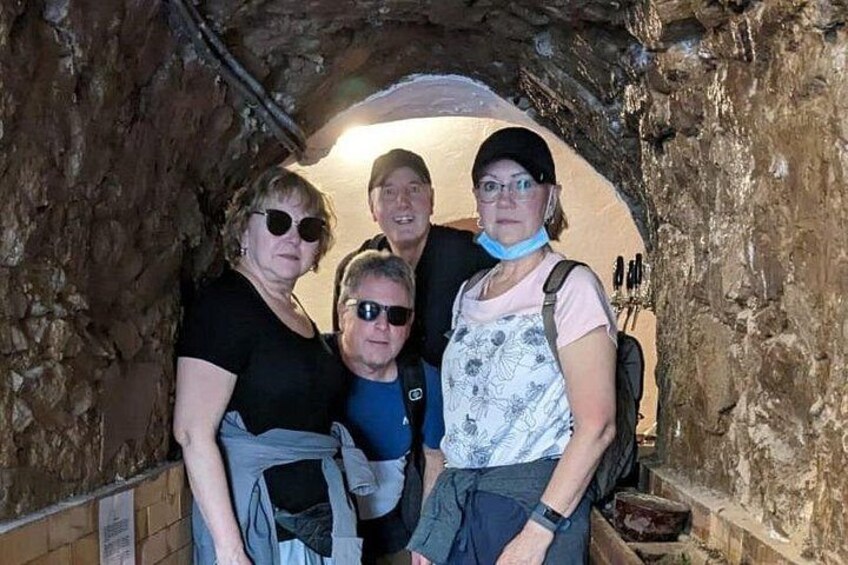 Un grupo de personas de pie en un túnel de piedra. 5