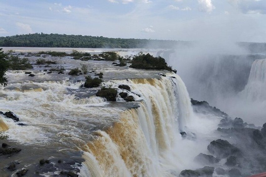 A powerful waterfall with multiple cascades, surrounded by rocky terrain and greenery. 5
