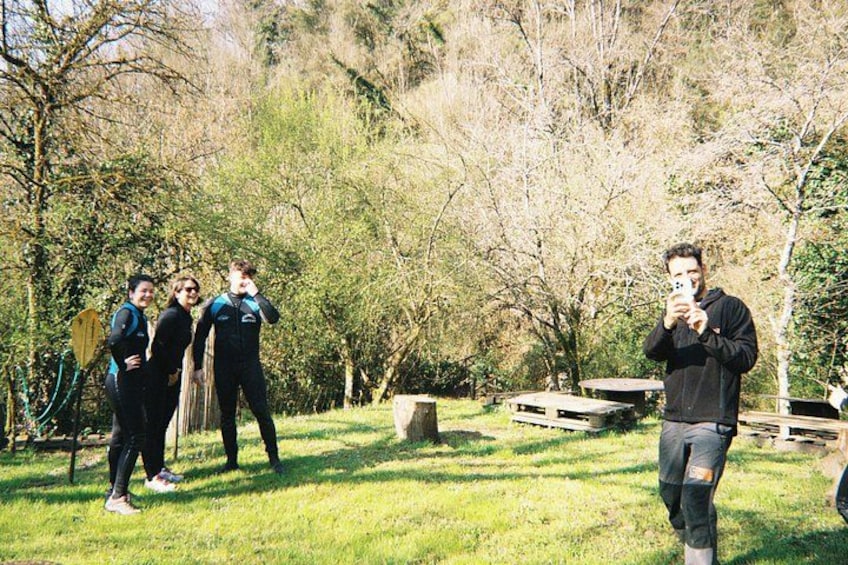 A group of people in a park with trees and picnic tables. 2
