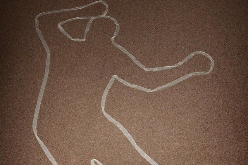A chalk outline of a person on a brown surface. 3