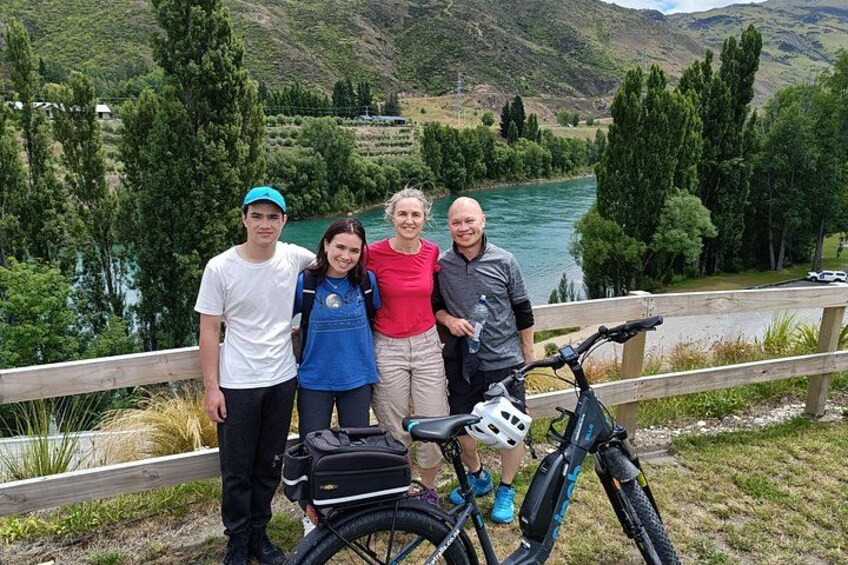 Een groep mensen staat bij een rivier met fietsen. 3