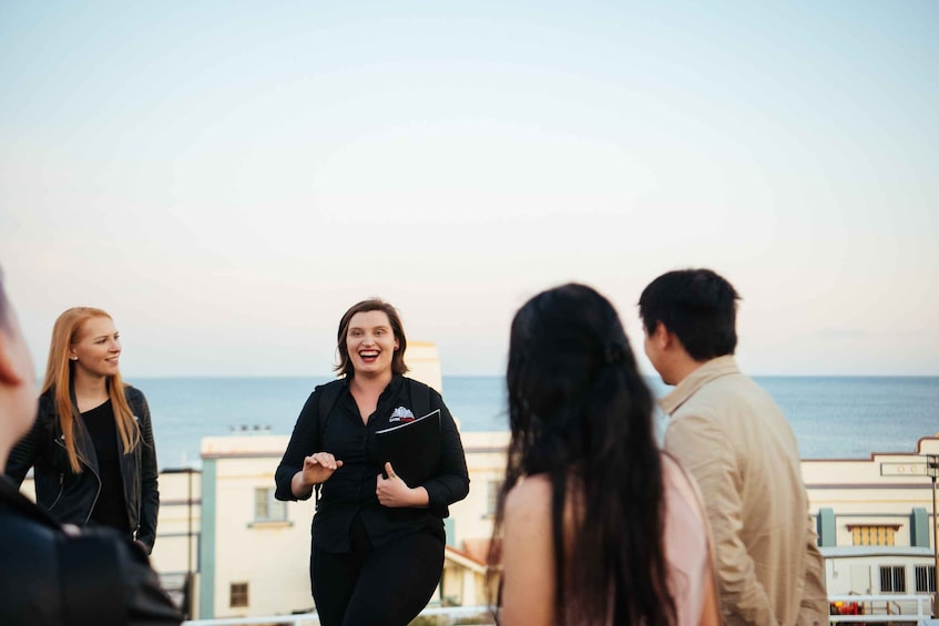 A group of people on a rooftop with a view of the sea. 1