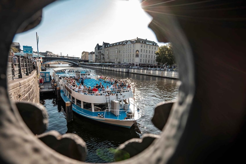 Un barco turístico en un río, con un puente al fondo. 3