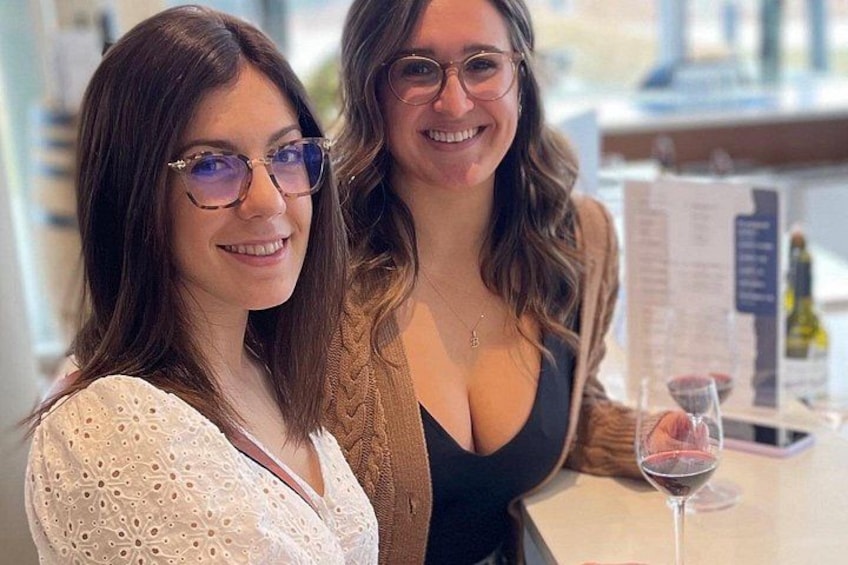 Two people sitting at a table with a menu and a glass of wine. 4