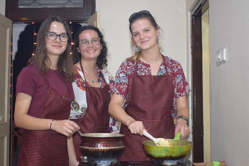 Tres personas con delantales, una removiendo un tazón verde, otra sosteniendo una cuchara, y una tercera con un tazón sobre un soporte. 4