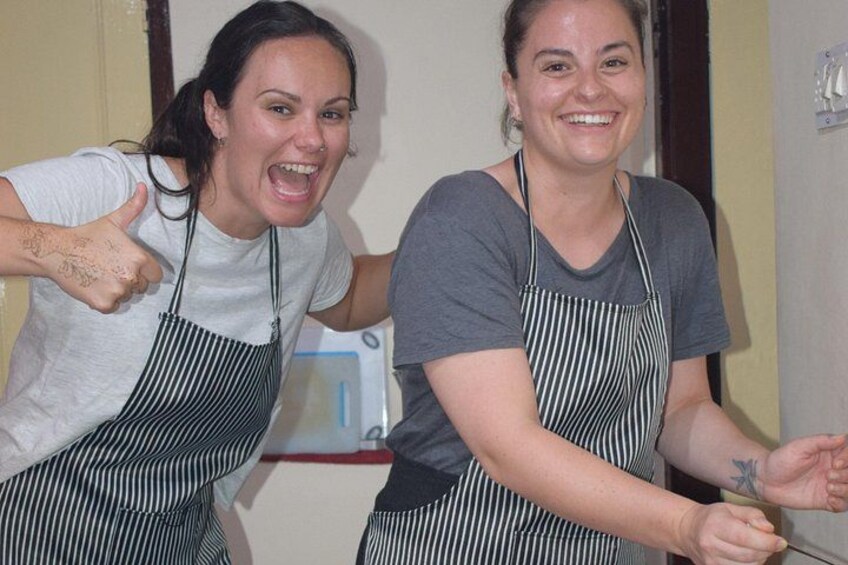 Dos personas con delantales a rayas, una levantando el pulgar. 5
