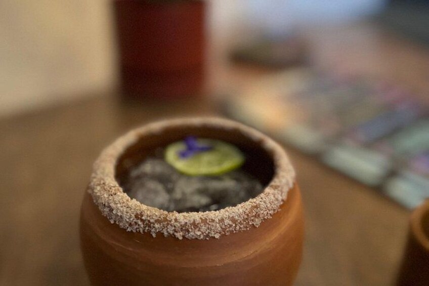 A small terracotta pot with a sugar-coated rim, containing a dark substance and a green leaf. 3