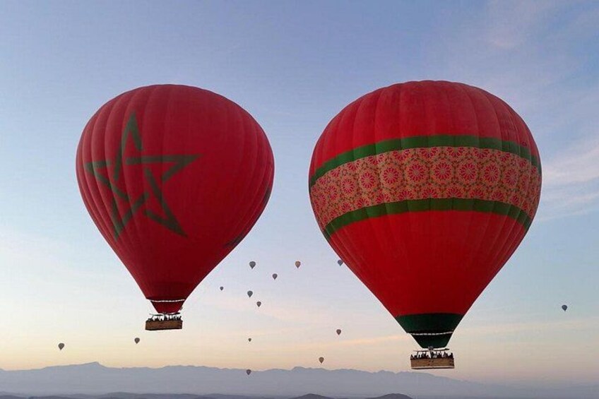 Två varmluftsballonger med distinkta mönster som flyger mot en klar himmel. 4