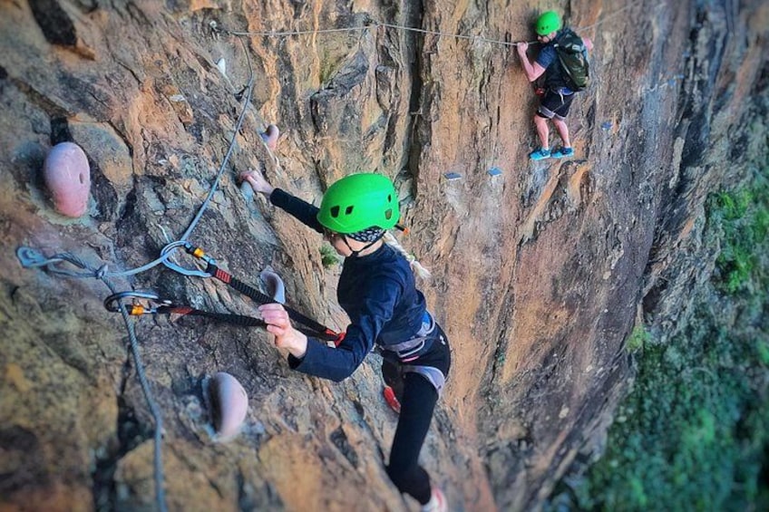 A person climbing a rock face with climbing gear. 4