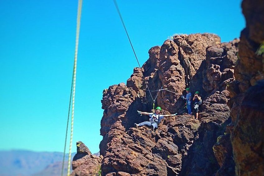 A person rappelling down a rocky cliff. 2