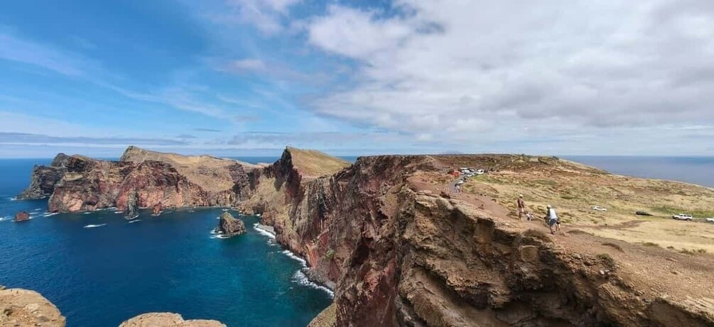 A coastal cliff with a view of the ocean and a distant shoreline. 5