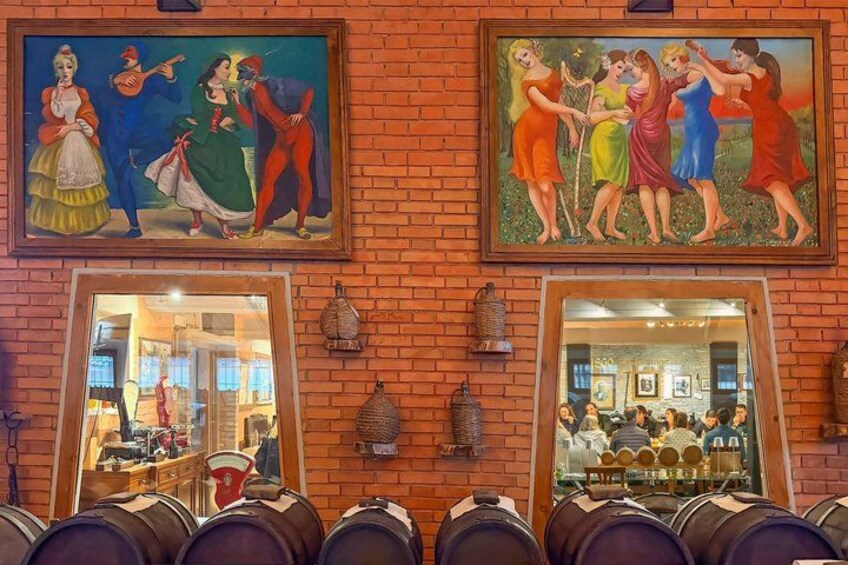 Pared de ladrillo con dos cuadros y una sección espejada que refleja una zona de bar. 5