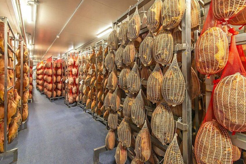 Un área de almacenamiento con filas de productos envasados, incluyendo bolsas grandes y cestas tejidas. 4