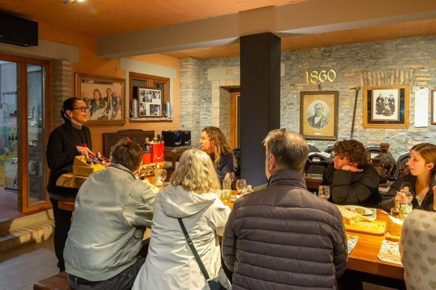 Un grupo de personas cenando en un restaurante con paredes de piedra y cuadros enmarcados. 4